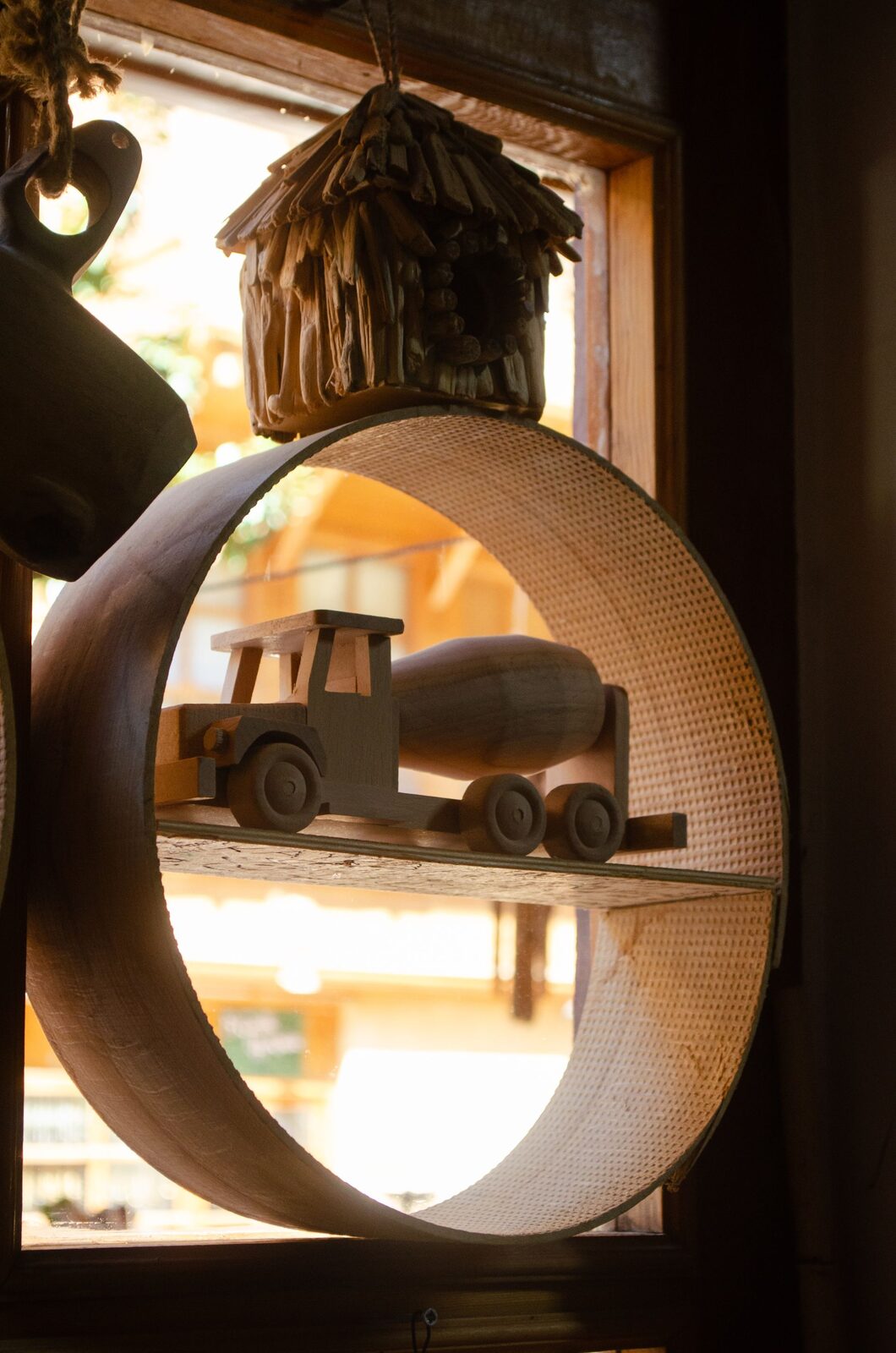 A handcrafted wooden toy truck displayed on a styled shelf